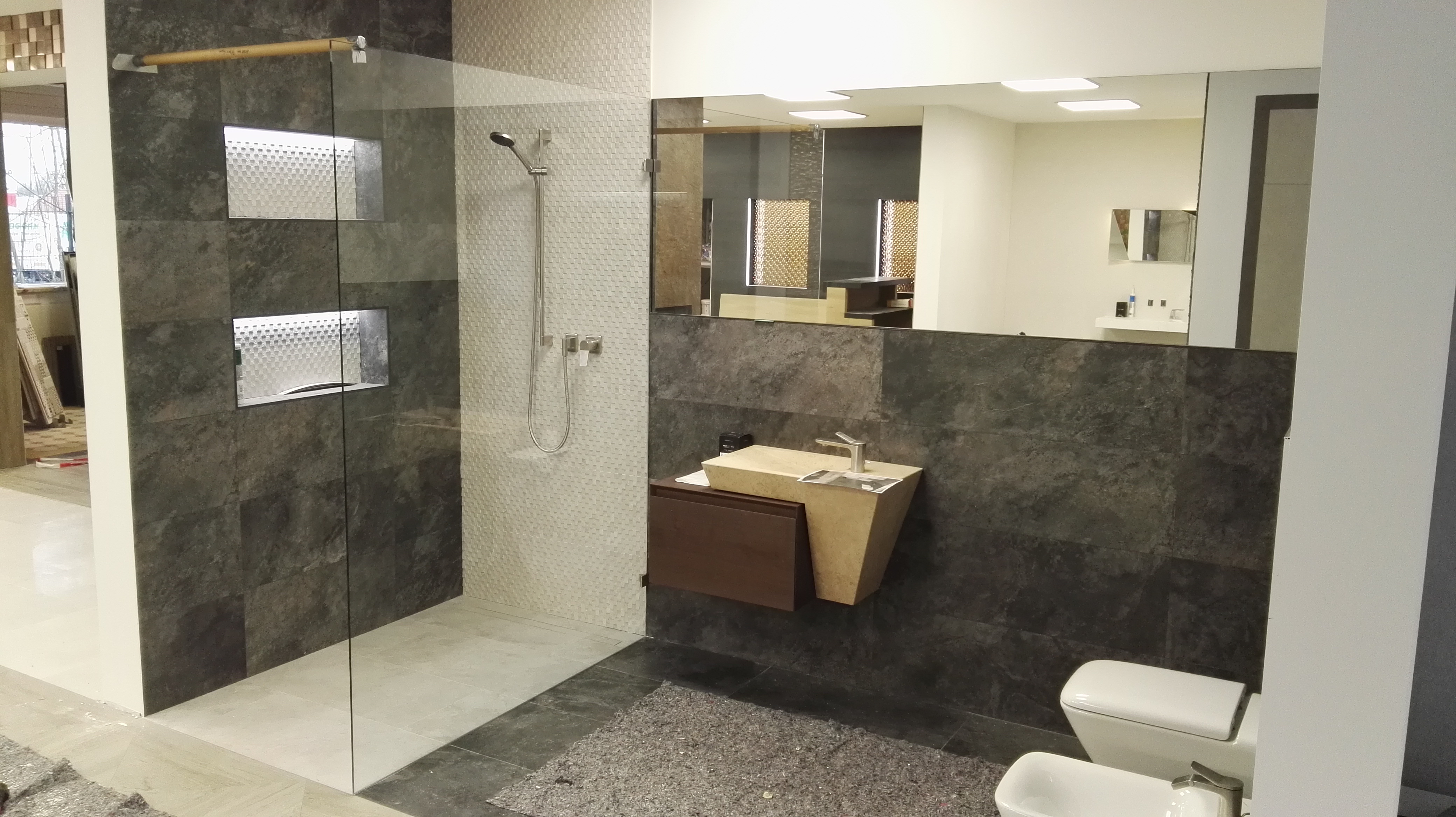 Modernes Bad mit begehbarer Dusche, dunklen Fliesen und Hängeschrank