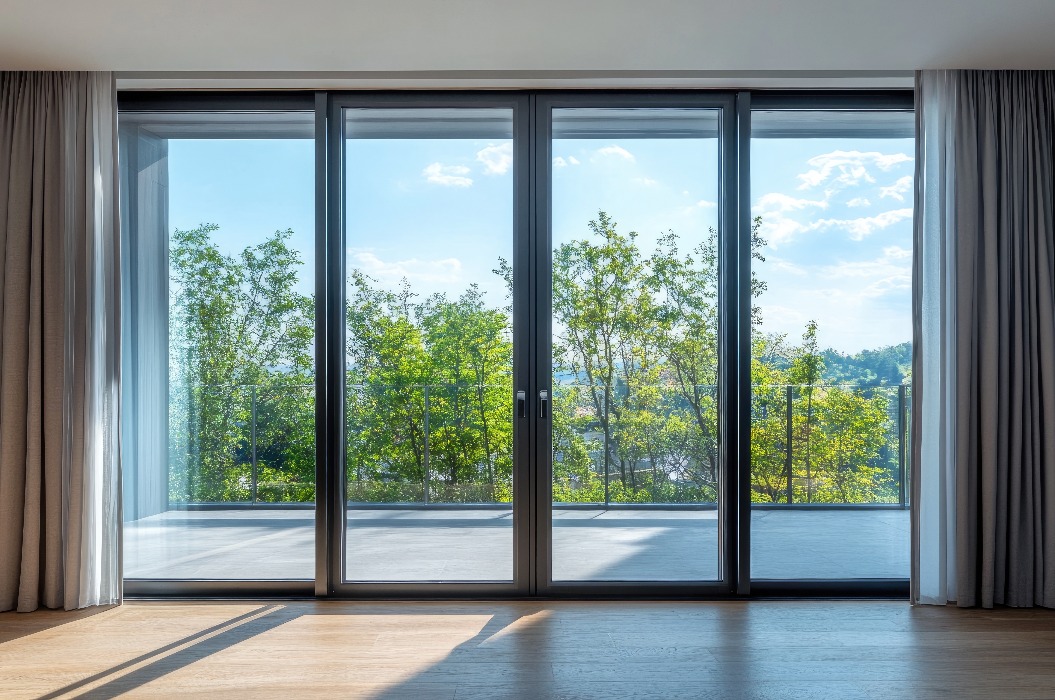 Große Glasschiebetüren mit Verdunkelungsvorhängen, die in einem modernen Zuhause Privatsphäre und Lichtregulierung gewährleisten.